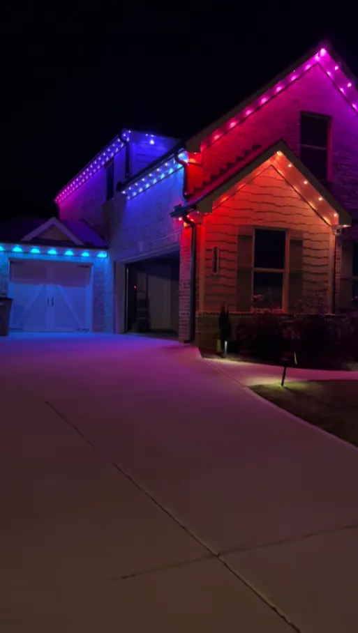 Two-story home at night with multi-color permanent LED lighting