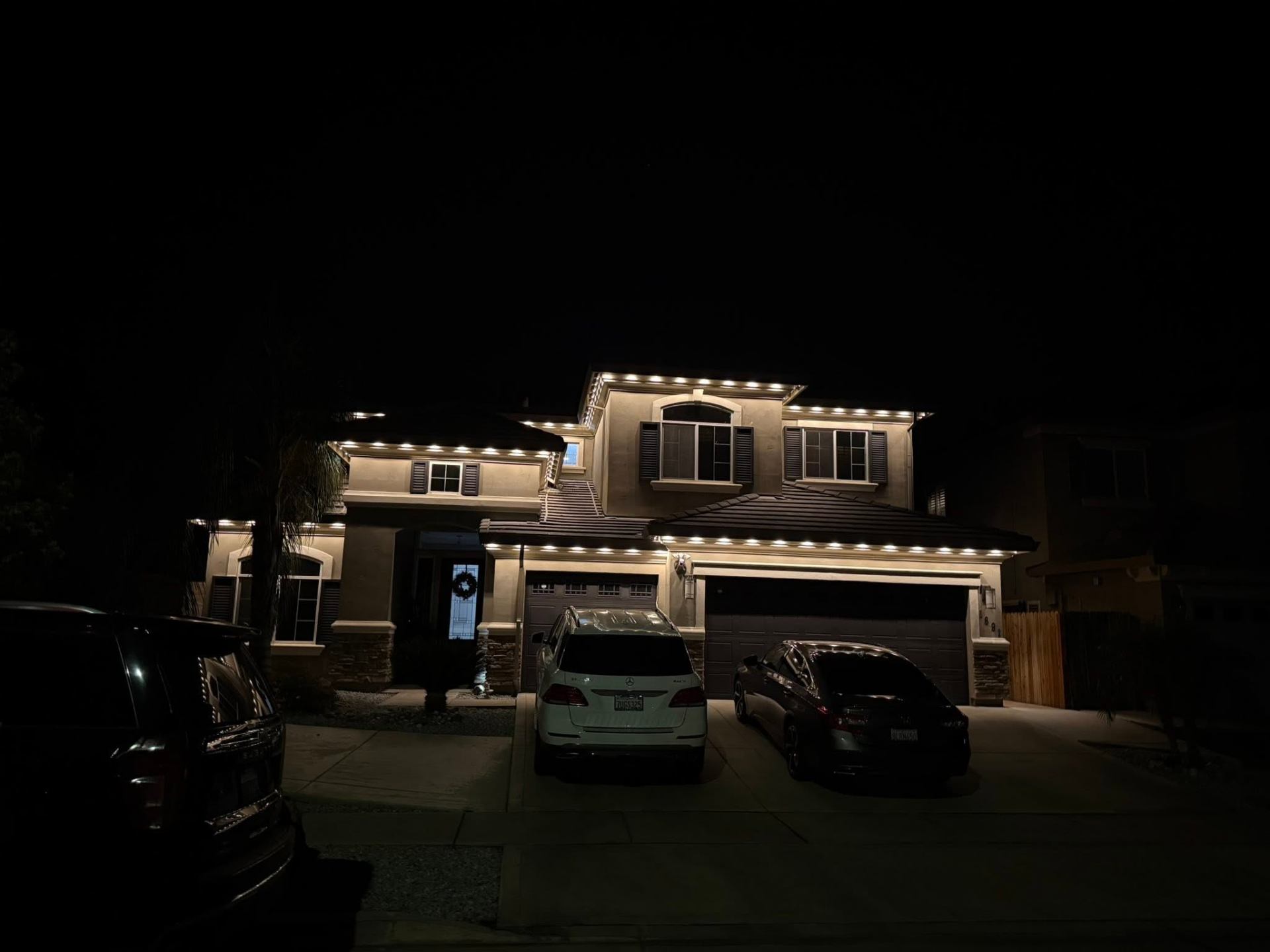Home with warm white permanent LED roofline at night